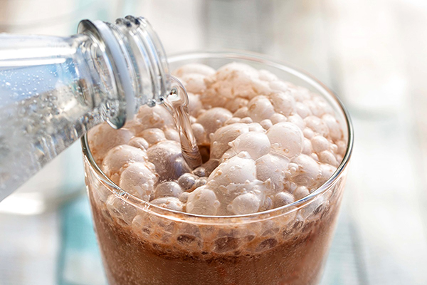 Soda water pouring into allergy-friendly chocolate egg cream soda